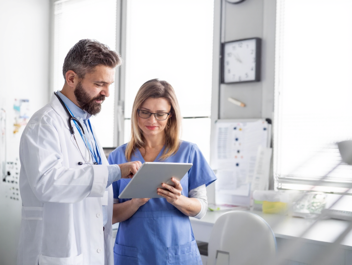 Doctor and nurse reviewing a patient chart together in a clean, bright clinic